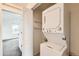 Convenient in-unit laundry area with stacked washer and dryer and overhead shelving at 4795 E 98Th Pl, Thornton, CO 80229