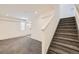 Carpeted living room with white walls and a staircase, offering ample space at 4795 E 98Th Pl, Thornton, CO 80229