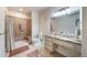 Well-lit bathroom featuring a shower with seat, granite countertops, and accessible features at 12136 Desert Hills St, Parker, CO 80138