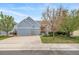 Inviting home featuring a well-manicured lawn, mature trees, and a spacious two-car garage for convenience at 12136 Desert Hills St, Parker, CO 80138