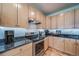 Close up view of the stainless steel appliances, granite counter tops, backsplash, and wood cabinets in the kitchen at 12136 Desert Hills St, Parker, CO 80138