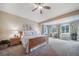 Spacious main bedroom with a ceiling fan and sitting area by the large windows at 12136 Desert Hills St, Parker, CO 80138
