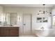 Modern bathroom featuring a soaking tub, wood vanity, stylish lighting, and elegant finishes at 2758 Utica St, Denver, CO 80212