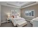 Calm main bedroom featuring a tray ceiling, neutral colors, and natural light from the window at 12717 Madison Ct, Thornton, CO 80241