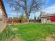 Backyard featuring well-maintained lawn, garden beds, and mature trees at 675 S Quivas St, Denver, CO 80223