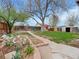 Well-maintained backyard featuring a large tree, lush green grass, and garden beds at 675 S Quivas St, Denver, CO 80223