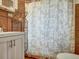 Tiled bathroom with a vanity, shower, shelving unit, and decorative shower curtain at 675 S Quivas St, Denver, CO 80223