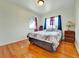 Cozy bedroom with hardwood floors, natural light from the window, and a comfortable bed at 675 S Quivas St, Denver, CO 80223