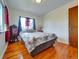Bedroom featuring hardwood floors, a comfortable bed, natural light, and a closet at 675 S Quivas St, Denver, CO 80223
