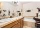 Bathroom with double vanity, soaking tub, tile accents, and stylish decor at 6694 S Rome St, Aurora, CO 80016