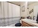 Cozy bathroom featuring patterned shower curtain, wood vanity, and decorative wall art at 6694 S Rome St, Aurora, CO 80016