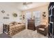 Bright bedroom featuring a trundle bed, neutral decor, and a cozy armchair beneath a ceiling fan at 6694 S Rome St, Aurora, CO 80016