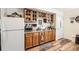 Bright kitchenette boasts wooden cabinets, granite countertops, and a wine rack above sink at 6694 S Rome St, Aurora, CO 80016