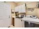 A well-organized laundry room equipped with modern washer and dryer units, cabinets, and a sink at 6694 S Rome St, Aurora, CO 80016