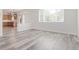 Bright, neutral room with stylish gray wood-look flooring and open access to kitchen at 19466 E 59Th Dr, Aurora, CO 80019