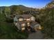 Scenic aerial view of a two-story home with a two-car garage nestled in a wooded area at 31402 N Bermuda Dunes Dr, Evergreen, CO 80439