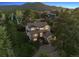 Panoramic aerial view of home surrounded by lush greenery and a mountain backdrop, showing its prime location at 31402 N Bermuda Dunes Dr, Evergreen, CO 80439