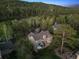 Aerial view of a house nestled amongst lush trees, showcasing its peaceful and secluded setting at 31402 N Bermuda Dunes Dr, Evergreen, CO 80439