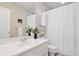Well-lit bathroom featuring a white sink vanity, a framed mirror, and a shower with a white curtain at 31402 N Bermuda Dunes Dr, Evergreen, CO 80439
