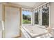Bright primary bathroom featuring a soaking tub with a view, dual sinks, and great natural light at 31402 N Bermuda Dunes Dr, Evergreen, CO 80439