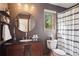 Stylish bathroom features a dark vanity with round mirror, and a window with natural light at 31402 N Bermuda Dunes Dr, Evergreen, CO 80439