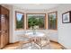 Cozy breakfast nook with hardwood floors, three large windows offering great views, and modern decor at 31402 N Bermuda Dunes Dr, Evergreen, CO 80439