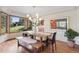 Light-filled dining area showcasing a wooden table with benches, stylish lighting, and lush outdoor views at 31402 N Bermuda Dunes Dr, Evergreen, CO 80439