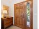 Charming entryway with a wooden door and a side window, complemented by a stylish dresser and decor at 31402 N Bermuda Dunes Dr, Evergreen, CO 80439