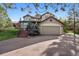 Charming home exterior with a well-maintained lawn, stairs leading to the entrance, and an attached garage at 31402 N Bermuda Dunes Dr, Evergreen, CO 80439