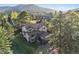 Aerial view of a home with mountains and trees in the background at 31402 N Bermuda Dunes Dr, Evergreen, CO 80439