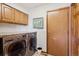 Practical laundry room featuring modern washer and dryer units with wooden cabinets above at 31402 N Bermuda Dunes Dr, Evergreen, CO 80439