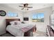 Comfortable bedroom featuring a ceiling fan, decorative fireplace, and ample natural light at 12794 Tamarac St, Thornton, CO 80602