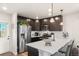Modern kitchen with stainless steel appliances, dark wood cabinets, and white countertops at 12794 Tamarac St, Thornton, CO 80602