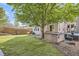 A backyard with a hot tub, patio seating, a well-maintained lawn, and mature trees at 10908 Oakshire Ave, Highlands Ranch, CO 80126