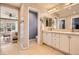 Bright bathroom with double vanity, patterned wallpaper, and doorway to bedroom at 10908 Oakshire Ave, Highlands Ranch, CO 80126