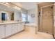 Bathroom featuring dual sinks, soaking tub, and walk-in shower at 10908 Oakshire Ave, Highlands Ranch, CO 80126
