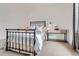 Simple bedroom with a black iron bed frame, carpeted floor, and a side table at 10908 Oakshire Ave, Highlands Ranch, CO 80126