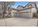 Home's exterior features a spacious three car garage and meticulous landscaping at 10908 Oakshire Ave, Highlands Ranch, CO 80126