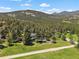 Aerial view of a house surrounded by lush greenery and mountains in the background at 31756 Buffalo Park Rd, Evergreen, CO 80439