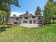 Back of house with large yard, deck with stairs, patio and a hot tub at 31756 Buffalo Park Rd, Evergreen, CO 80439