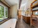 A luxurious bathroom featuring a soaking tub, double sinks, and natural stone accents at 31756 Buffalo Park Rd, Evergreen, CO 80439