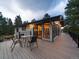 Outdoor deck with a table and chairs, offering a relaxing space for entertaining or enjoying the evening at 31756 Buffalo Park Rd, Evergreen, CO 80439