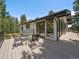 Outdoor deck with table and chairs and views of the surrounding trees and landscape at 31756 Buffalo Park Rd, Evergreen, CO 80439