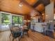 Charming dining area with wood floors, deck access, and adjacent kitchen with breakfast bar at 31756 Buffalo Park Rd, Evergreen, CO 80439