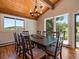 Charming dining room with wood ceiling, chandelier, natural light, and seating for eight at 31756 Buffalo Park Rd, Evergreen, CO 80439