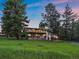 Exterior view of house with grass lawn and mature trees at 31756 Buffalo Park Rd, Evergreen, CO 80439