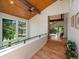 Hallway with wood floors, vaulted wood ceilings, and views to a balcony and the living room at 31756 Buffalo Park Rd, Evergreen, CO 80439