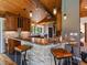 Beautiful kitchen with stone accents, granite counters, wood cabinets, and bar seating with industrial-style chairs at 31756 Buffalo Park Rd, Evergreen, CO 80439