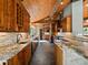 Spacious kitchen with stainless steel appliances, granite countertops, wooden cabinets, bar, and wood ceiling at 31756 Buffalo Park Rd, Evergreen, CO 80439