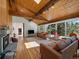 Open living space with hardwood floors, a stone fireplace, and large sliding doors to the deck at 31756 Buffalo Park Rd, Evergreen, CO 80439